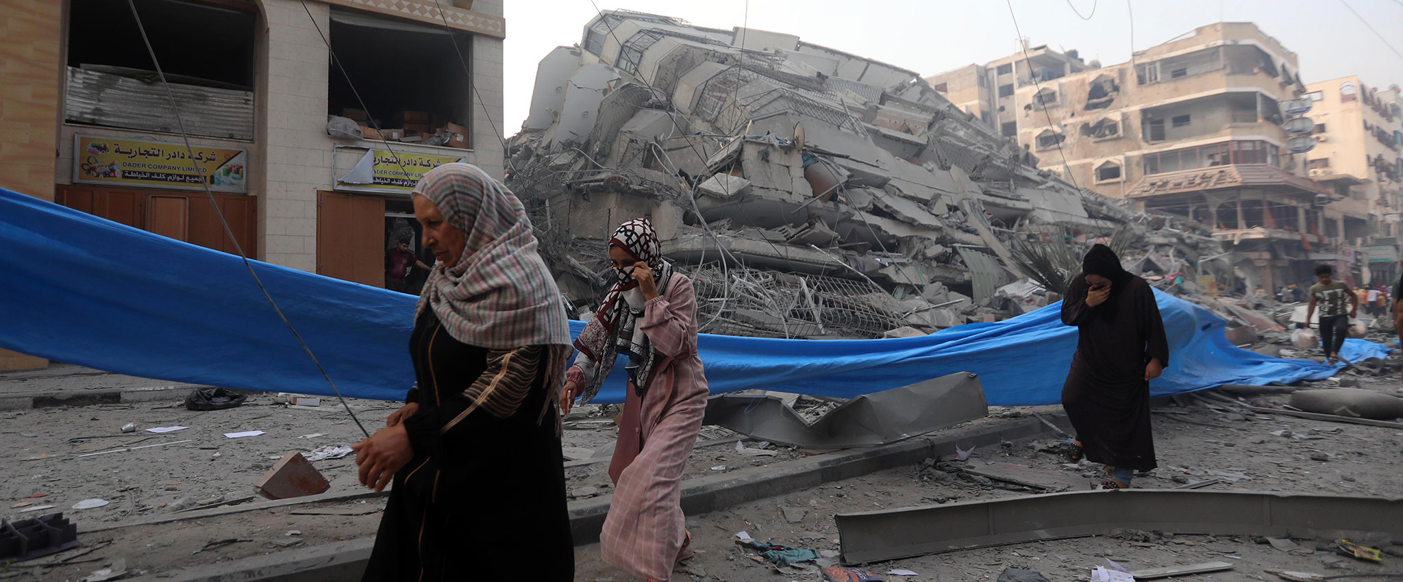 Women are seen in the Nasr neighbourhood of Gaza City on 7 October 2023 after their home was destroyed.