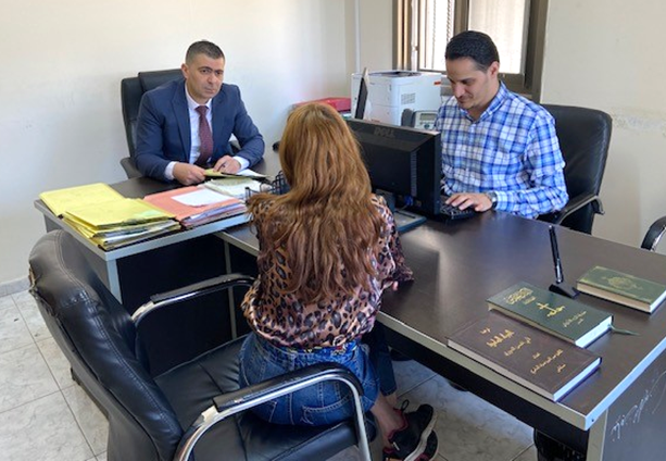 Public Prosecutor and Family Protection Prosecution from Violence Designee Abdel Latif Natour (left) consults with a survivor of violence seeking legal services. Photo © Abdel Latif Natour.