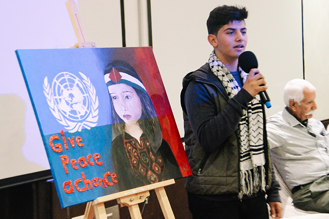 Young Palestinian presents his drawing made for the Open Day