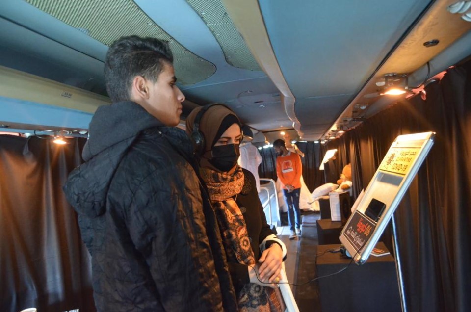 A woman and a man tour the Cologne Mobile Exhibition in Gaza City on Thursday 9 December 2021 / UN Women photo